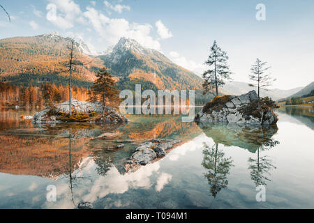 Schöner Blick auf die Bäume auf der Insel in die idyllische Landschaft am See Hintersee bei Sonnenuntergang, Berchtesgaden, Bayern, Deutschland Stockfoto