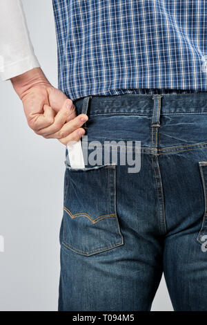 Mann legt ein leeres weißes Papier business card in seinem Rücken jeans Tasche, in der Nähe Stockfoto