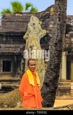 Buddhistischer Mönch in orange Robe von Naga Schlange statue am berühmten buddhistischen Tempelanlage Angkor Wat, Angkor, Siem Reap, Kambodscha. Stockfoto