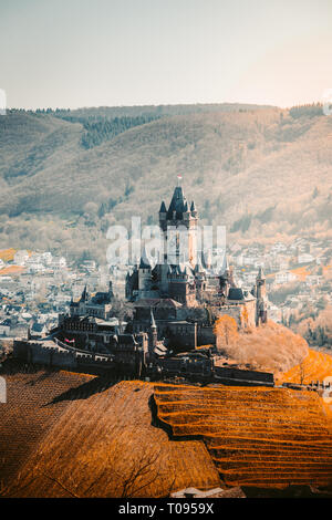 Schöner Blick auf die Altstadt von Cochem mit berühmten Reichsburg auf der Spitze eines Hügels, an einem sonnigen Tag mit blauen Himmel im Frühjahr Stockfoto