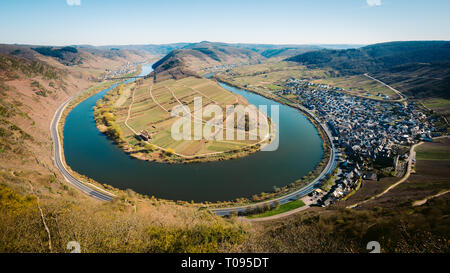Panoramablick auf Schiff auf dem berühmten Mosel an der Moselschleife mit der historischen Altstadt von Bremm an einem schönen sonnigen Tag mit blauen Himmel im Frühling, Stockfoto
