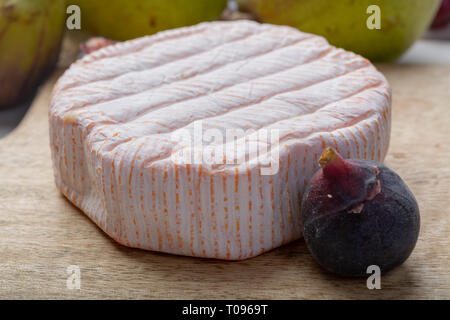 Rundes Stück französischer Käse Fleur Rouge aus Kuhmilch hergestellt als Dessert serviert mit frischen Feigen und Birnen Nahaufnahme Stockfoto