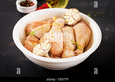 Roh roh marinierte Hähnchenschenkel, Drumsticks für das Kochen auf dunklen Tisch. Asiatische Küche. Stockfoto
