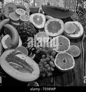 Vitamin Nahrung und Gesundheit essen Wassermelone und Honigmelone mit Banane. orange Ananas Zitrone mit Grapefruit und Trauben Layout. Frische Früchte auf Holz Stockfoto