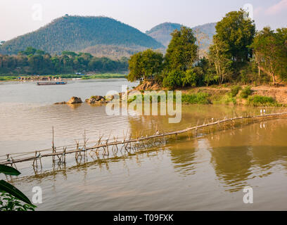 Blick auf den Fluss Mekong mit Klapprigen Bambus Zuckerrohr Brücke über den Fluss Nam Kahn Nebenarm des Mekong, Luang Prabang, Laos, Indochina, Se Asien Stockfoto