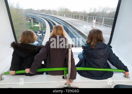 Drei Schwestern, Mädchen, Kinder, Kinder, fahren mit dem Interterminal-Shuttleservice, dem Gatwick Shuffle-Zug zwischen North Terminal und South Terminals Gatwick Airport, London, UK. (104) Stockfoto