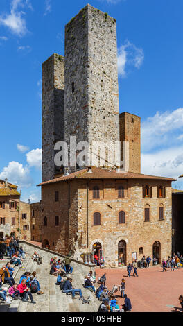 Touristen auf der Treppe an der Piazza Duomo in San Gimignano, Italien sitzen Stockfoto