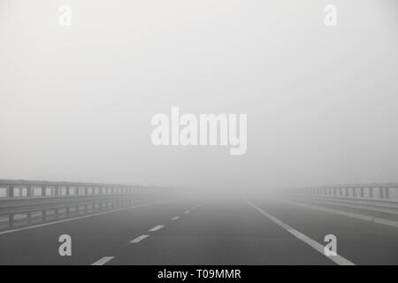 Sehr dichte gefährliche Nebel auf der Autobahn im Winter ohne Autos Stockfoto