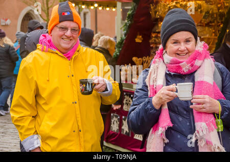 Touristische Paar trinken Glühwein Glühwein in Rothenburg andenken Becher an Deutschen Weihnachtsmarkt Stockfoto