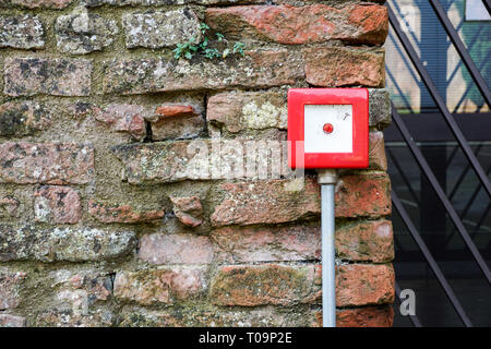 Feueralarm auf weißem Zement Wand für Sicherheit Warnung, Push Button Feueralarm im Gebäude, isolierte Feueralarm botton Box Stockfoto