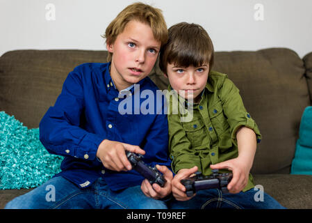 Zwei kleine Brüder auf einer Couch, Spielen, computer spiel Stockfoto