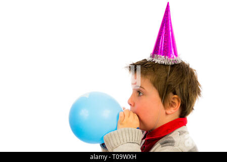 fröhlicher Junge mit einer Party, einem Ballon zu sprengen. Stockfoto