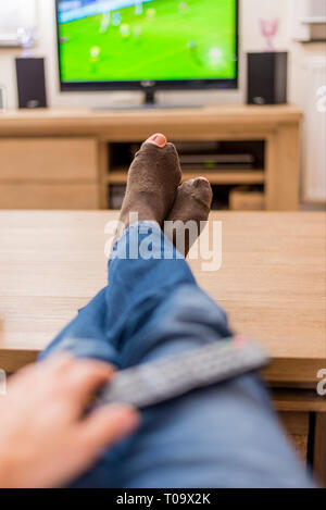 Mann mit Löchern in Fussball Socken Stockfoto