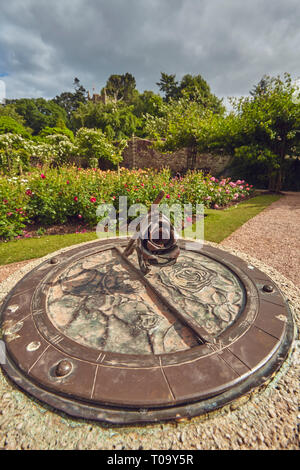 Eine Sonnenuhr in einem Rosengarten in der Höhe des Sommers, Cockington, Torquay, Devon, Großbritannien. Stockfoto