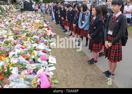 Christchurch, Canterbury, Neuseeland. 18 Mär, 2019. Studenten aus Momoyamagkuin High School in Osaka, stehen vor der Blumen für die Opfer von der Christchurch Moscheen Terroranschläge gelegt. Rund 50 Personen hat angeblich in der Christchurch getötet wurden Moscheen Terroranschlag schießen Targeting die Masjid Al Noor Moschee und die linwood Moschee. Quelle: Adam Bradley/SOPA Images/ZUMA Draht/Alamy leben Nachrichten Stockfoto