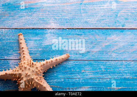 Top view of big starfish on blue wood textured background - with copy space - summer time and holiday backdrop concept Stockfoto