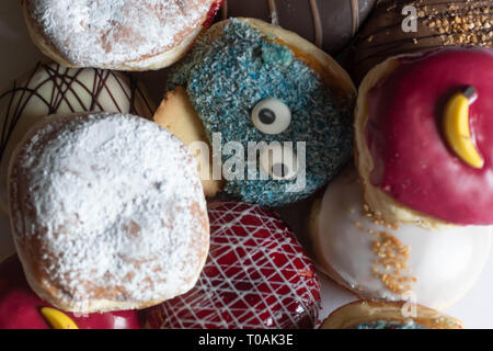 Leckere frisch gebackene Berliner mit verschiedenen Toppings Stockfoto