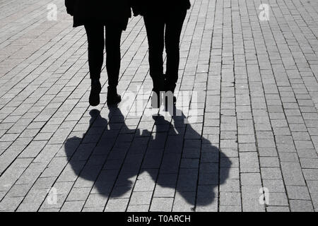 Silhouetten und Schatten der zwei Frauen auf der Straße. Konzept der weiblichen Freundschaft, Diskussion, Klatsch, Zwillinge, dramatische Lebensgeschichte Stockfoto