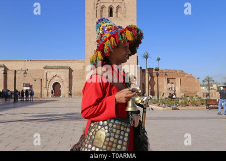 Gerrab (Wasser Verkäufer) außerhalb der Koutoubia Moschee (Ostseite), Medina, Marrakesch, Marrakesh-Safi region, Marokko, Nordafrika Stockfoto