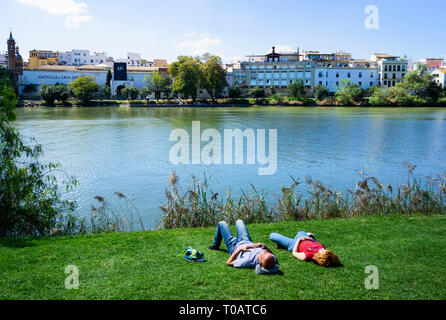 Ein junges Paar in einer Siesta neben dem Fluss Guadalquivir in Sevilla Stockfoto