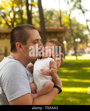 Vater halten und küssen neugeborenes Mädchen Stockfoto