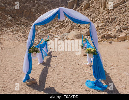 Setup von Hochzeit ehe Gang mit Vorhängen und Bogen in einem abgelegenen ariden Wüstenklima Stockfoto