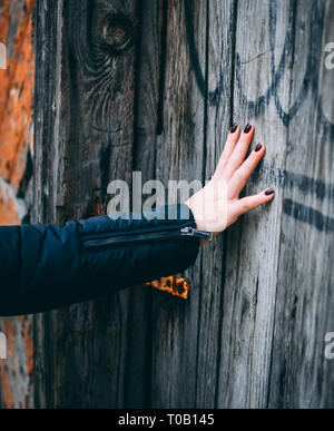 Frau öffnet alte Holztür Stockfoto