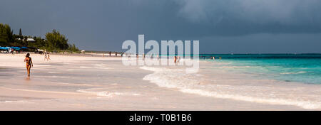 Frau Wandern in der Brandung, auf Pink Sands Beach, Harbour Island, Eleuthera, Bahamas, in der Karibik. Stockfoto
