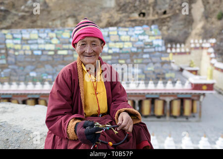 Lächelnde Nonne vor langen Mani stein Wand an der Ser Gergyo (Ani Gompa) Nonnenkloster, Tagong, Sichuan, China Stockfoto