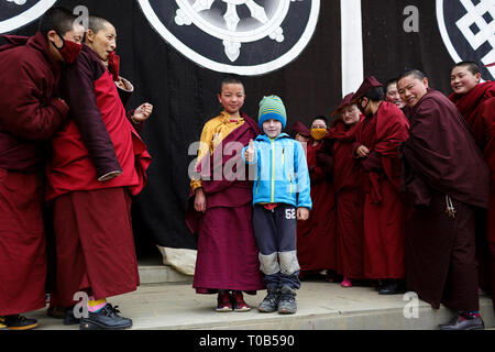 Nonnen mit einem westlichen Jungen an der Ani Gompa Tagong Kloster, Tagong, autonomen Bezirk Garzê der Tibeter, Sichuan, China Stockfoto