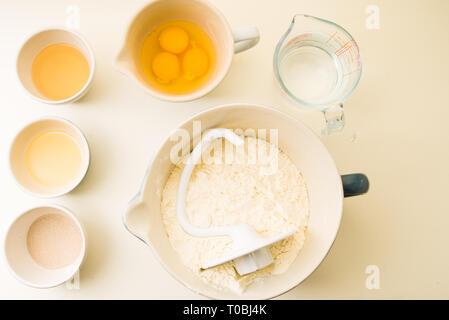 Schritt für Schritt ein leckeres Rezept challah vorzubereiten, Zutatenliste 500 g Backen von Weizen auf einem großen porcela jar, Ansicht von oben über einen gelben Hintergrund, Stockfoto