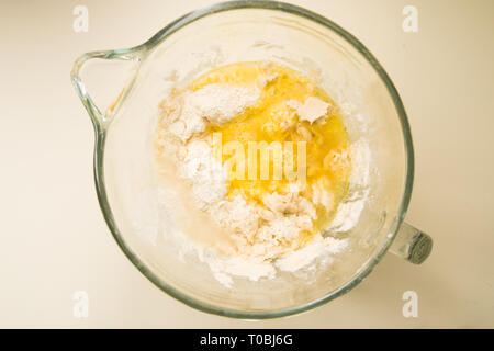 Schritt für Schritt ein leckeres Rezept challah vorzubereiten, Zutatenliste 500 g Backen von Weizen auf einem großen porcela jar, Ansicht von oben über einen gelben Hintergrund, Stockfoto