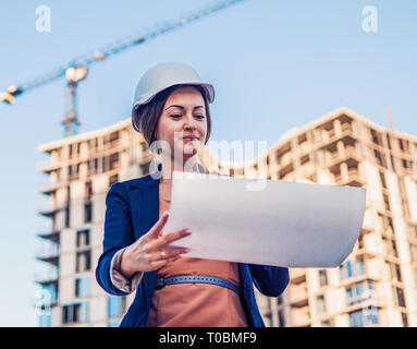Wunderschöne Business woman Ingenieur steht mit plan Papiere. Stockfoto