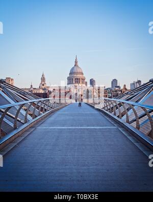 London Millennium Bridge am frühen Morgen. Blick auf den Dom St. Peter, ein Fotograf macht ein Foto von der Themse. Stockfoto