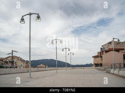 Plaza mit Straßenlaternen in Oliena Dorf, Nuoro Provinz, Insel Sardinien, Italien. Himmel voller Wolken. Stockfoto