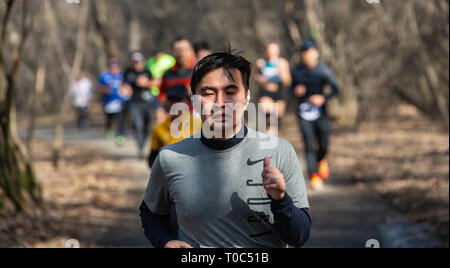 ALMATY, Kasachstan - 16. März 2019: Porträt einer stattlichen Reifen unbekannter Mann, der durch die Wälder im Frühjahr beim Marathon in der Stadt läuft Stockfoto