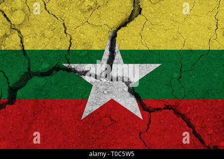 Myanmar Flagge auf dem Rissige Erde. Nationalflagge von Myanmar. Erdbeben, Dürre, Konzept Stockfoto