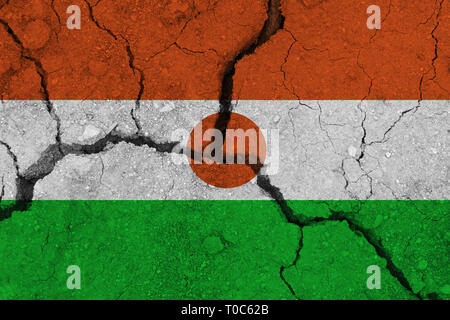 Niger Fahne auf dem Rissige Erde. Nationalflagge von Niger. Erdbeben, Dürre, Konzept Stockfoto