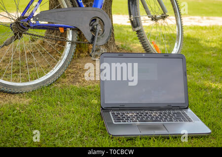 Srinagar, Jammu und Kaschmir, Indien - Stand: Juli 14, 2018: Ein Laptop auf Gras und ein Zyklus in der Nähe in einem öffentlichen Park geparkt werden Stockfoto