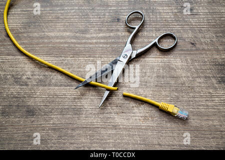 Zensur im Internet Konzept. Gelbe Kabel Internet Schnitt durch die Schere. Stockfoto