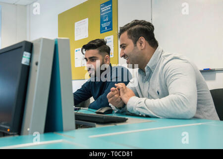 Internationale Studenten und Schüler im Computerraum einer Hochschule/Universität studieren und mit dem Desktop Computer Stockfoto