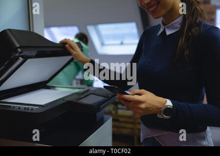 Mit Handy halten Xerox Kopierer in der hand Geschäftsfrau Stockfoto