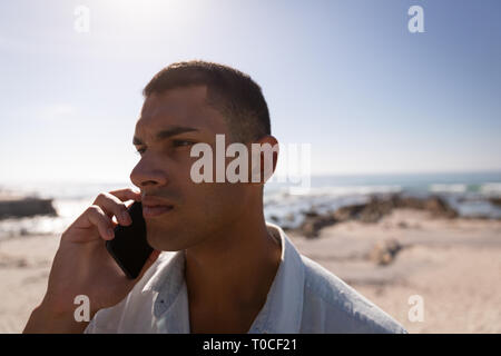 Mann Gespräch am Handy am Strand Stockfoto
