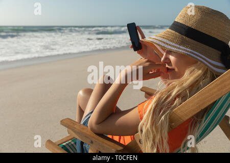 Junge kaukasier Frau relaxen im Liegestuhl am Strand Stockfoto