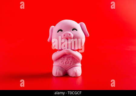 Ein rosa Nettes Schwein Maskottchen für das neue Jahr 2019 auf rotem Hintergrund Übersetzung für die Chinesen in Englisch ist Glück Stockfoto