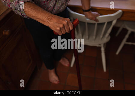 Active Senior woman Walking mit Stock in der Küche zu Hause. Stockfoto