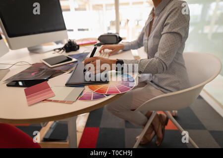 Grafik Designer über Grafik Tablett am Schreibtisch im Büro arbeiten Stockfoto