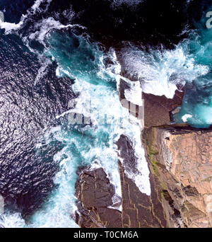 Atemberaubende overhead drone Schüsse der wilden Küste im Norden Schottlands. Hohe Klippen und Wellen auf die zerklüftete Küstenlinie. Stockfoto