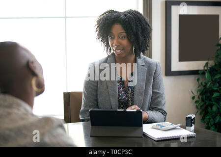 Schwarze weibliche Geschäftsfrau in einem Büro mit einem Client geben rechtliche Beratung über Steuern oder Darlehen. Die Frau könnte ein Rechtsanwalt oder ein cpa-Konto Stockfoto