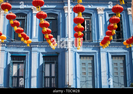 Rote Laternen hängen vor dem blauen Heritage Shophouse als Dekoration für das bevorstehende chinesische Neujahrsfest. Singapur. Stockfoto